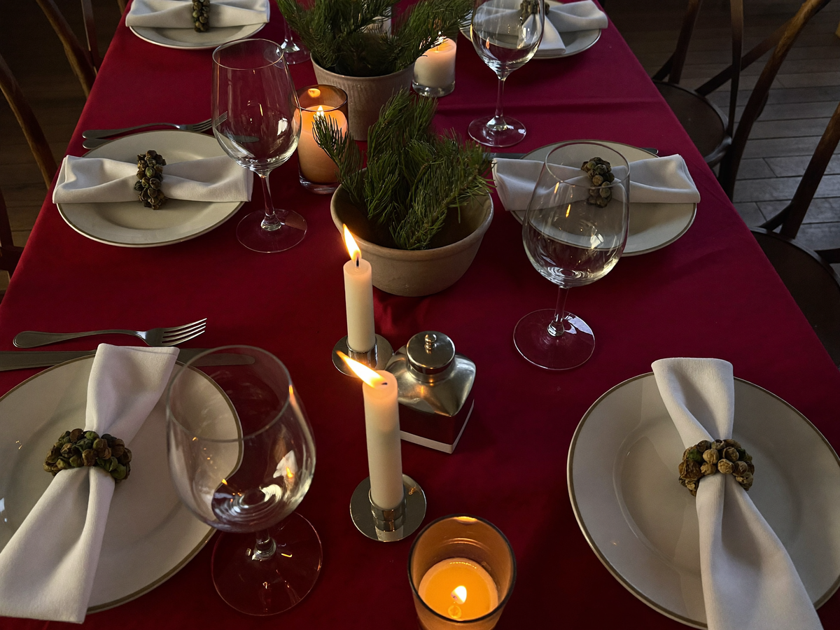 Table de Noël dressée, nappe rouge, bougies et branches de sapin